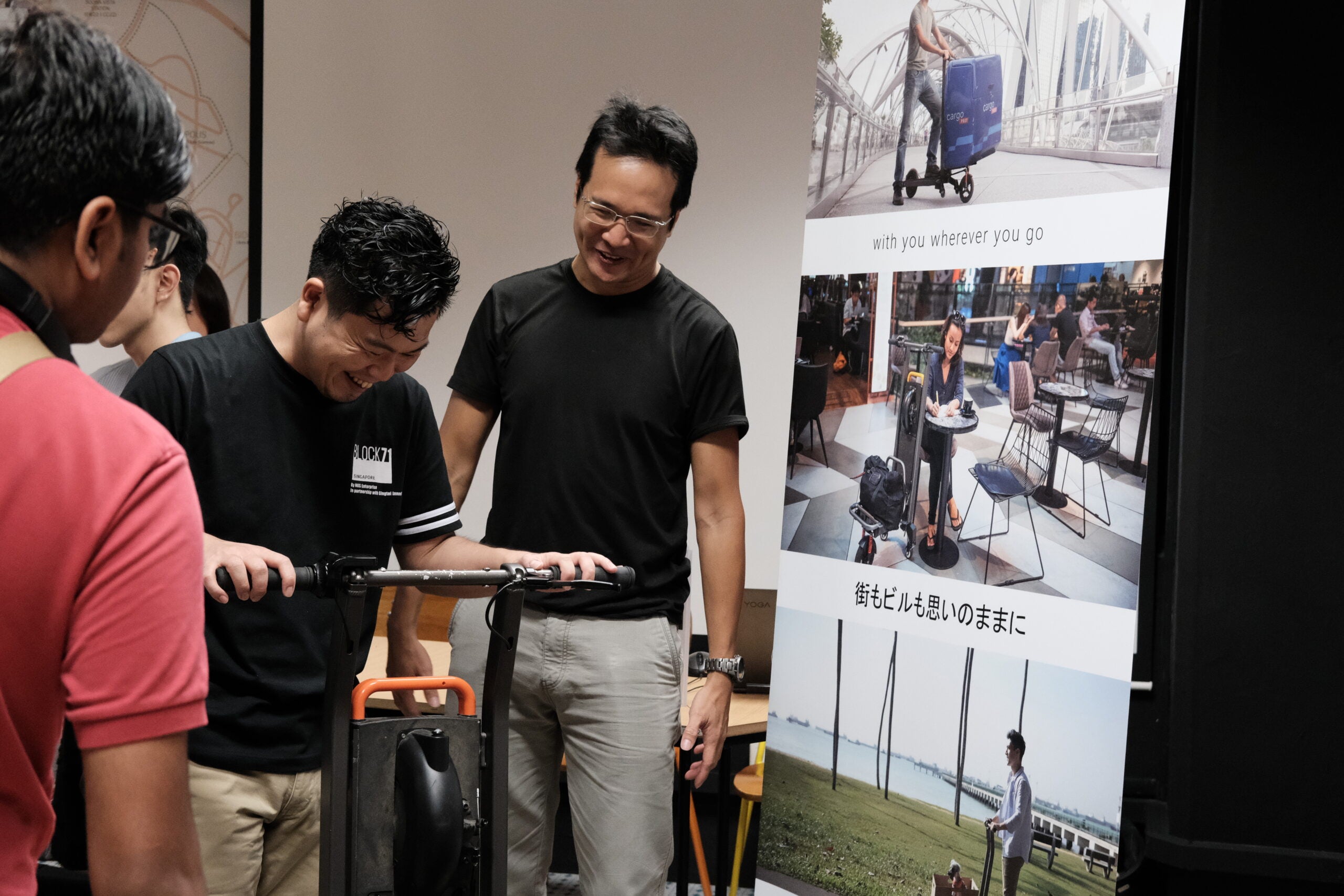 Witono Halim (right), engineer and founder of MIMO Motor, demonstrates their electric vehicle to attendees at an event, showcasing the innovative design and functionality of the product.